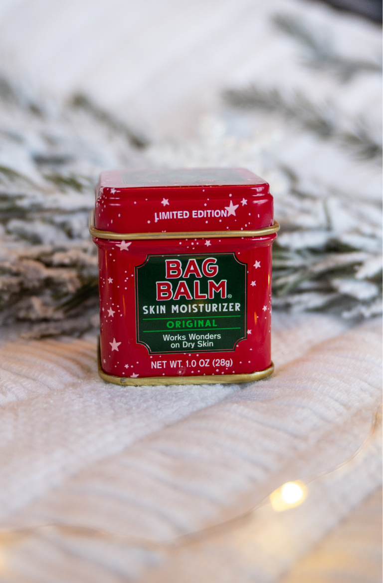 Red tin with stars Bag Balm 1oz tin on white background with snowy pine trees