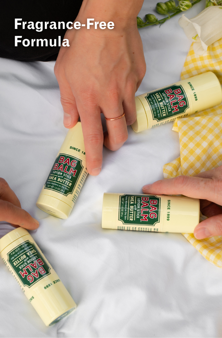 Hands reaching for Bag Balm lotion stick