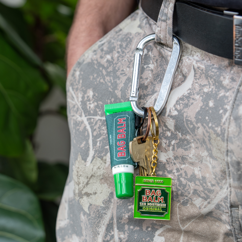 Bag Balm tube and keychain on a carabiner attached to a person's pocket.