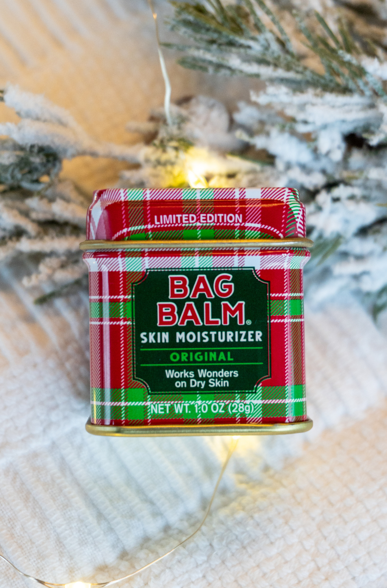 Red and green plaid tin of Bag Balm 1oz tin with plaid design on a Christmas tree background