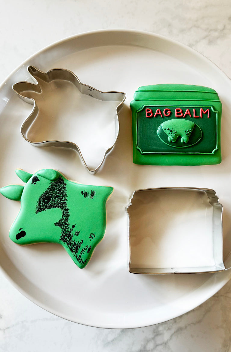 Cookie cutters shaped like Bag Balm tins and cow from bag balm logo, a fun addition to any kitchen.