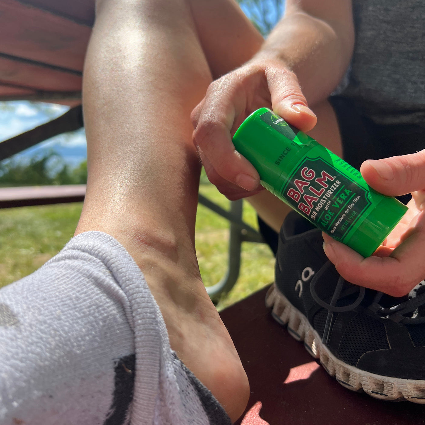 A person applying Bag Balm Skin Moisturizer to their heels