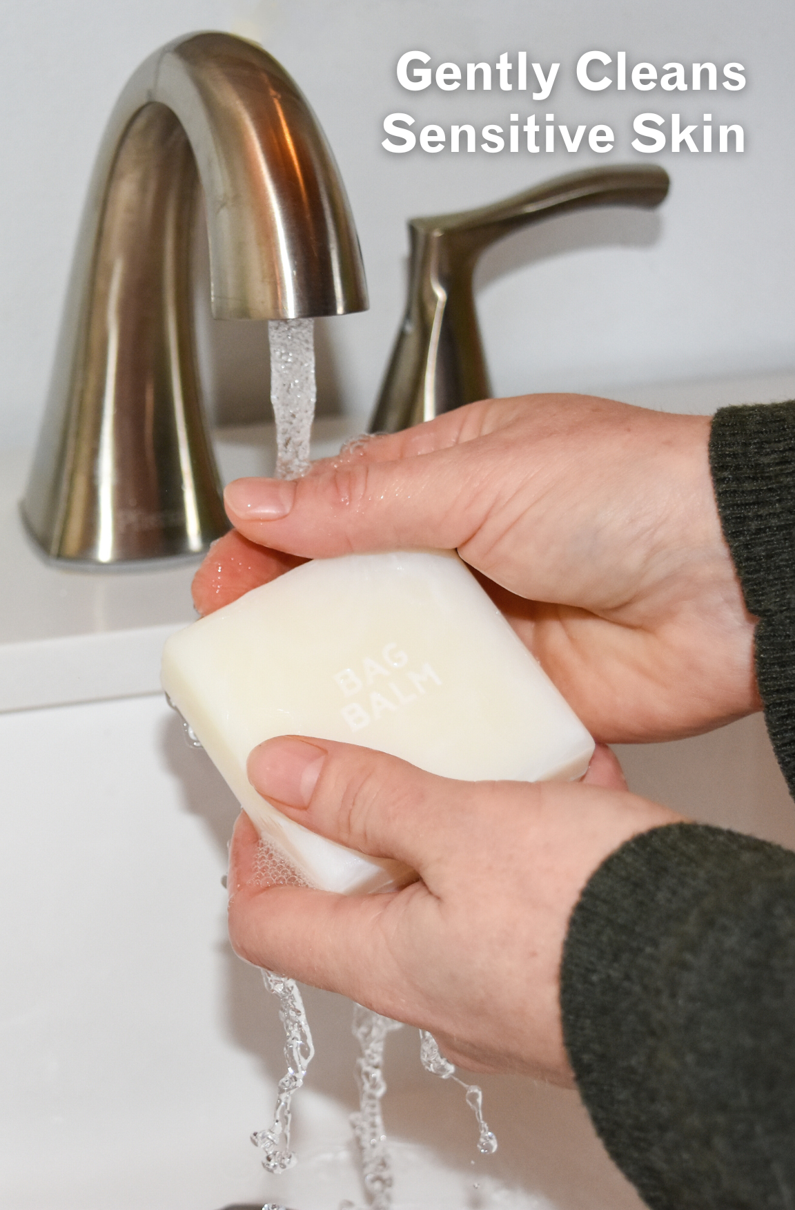 Hands under faucet holding bar of soap