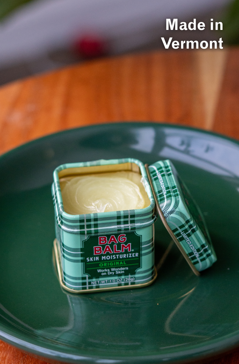 Green tin of BAG BALM on a green plate with 'Made in Vermont' text.