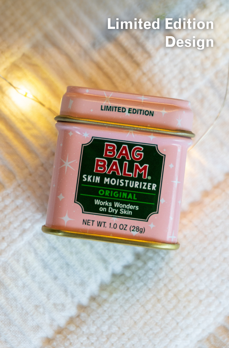 Pink can of Bag Balm skin moisturizer on a textured fabric background
