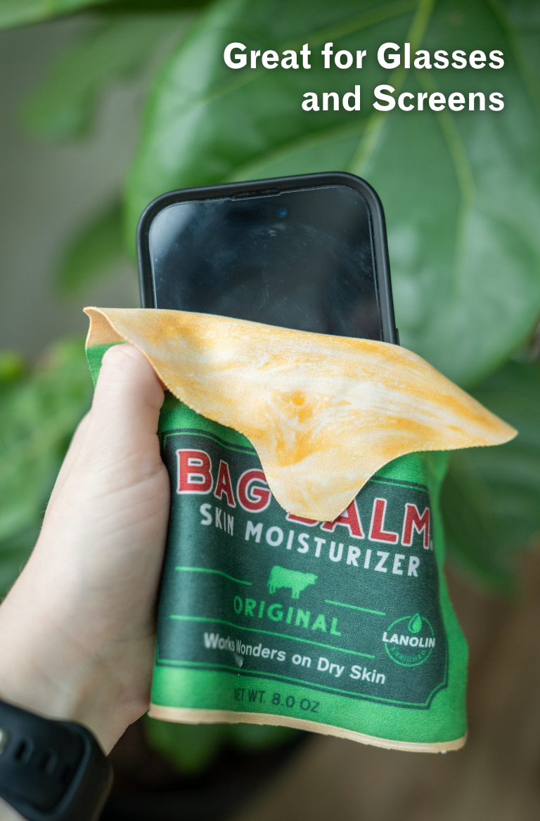 A glasses wipe shaped like a Bag Balm tin wiping a phone screen