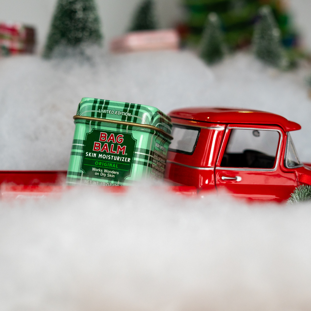 Red truck and green bag balm container on a snowy background