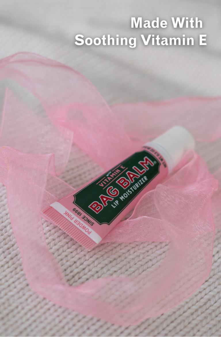Bag balm with vitamin E on a textured surface with pink tulle