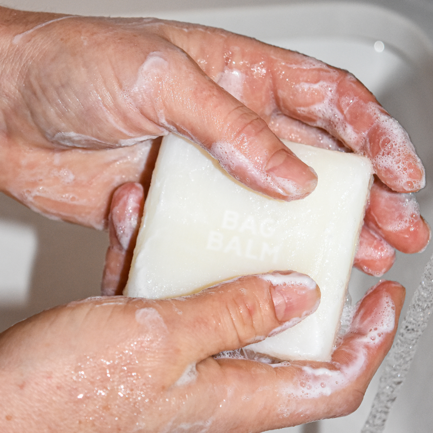 Hands holding sudsy soap