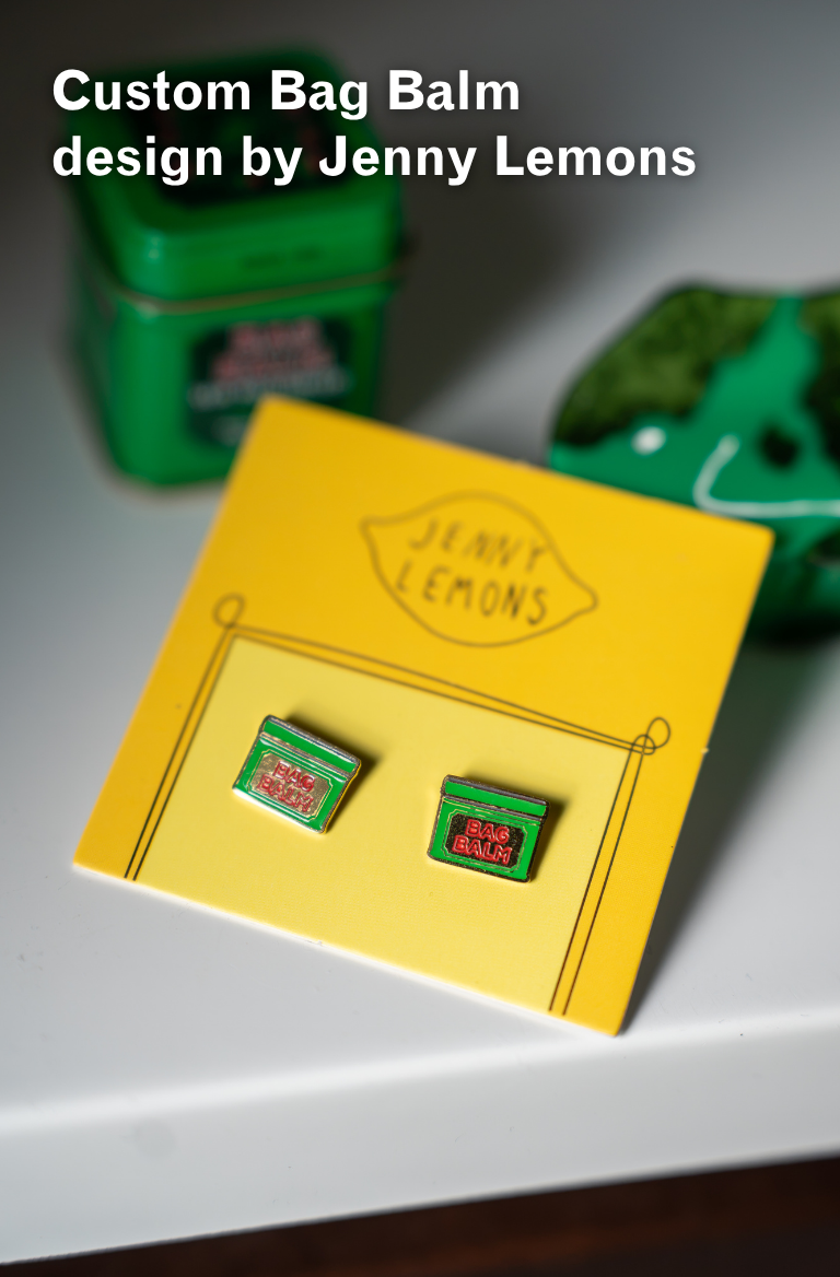 Bag Balm Stud Earrings laying on a white countertop